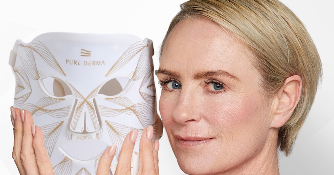 Woman in her 40s holding the Pure Derma LED light therapy face mask