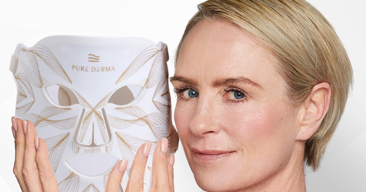 Woman in her 40s holding the Pure Derma LED light therapy face mask
