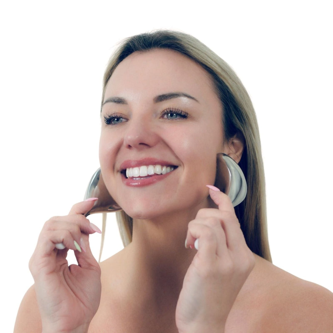 Woman using a cryo facial roller on her cheek against a clean white background