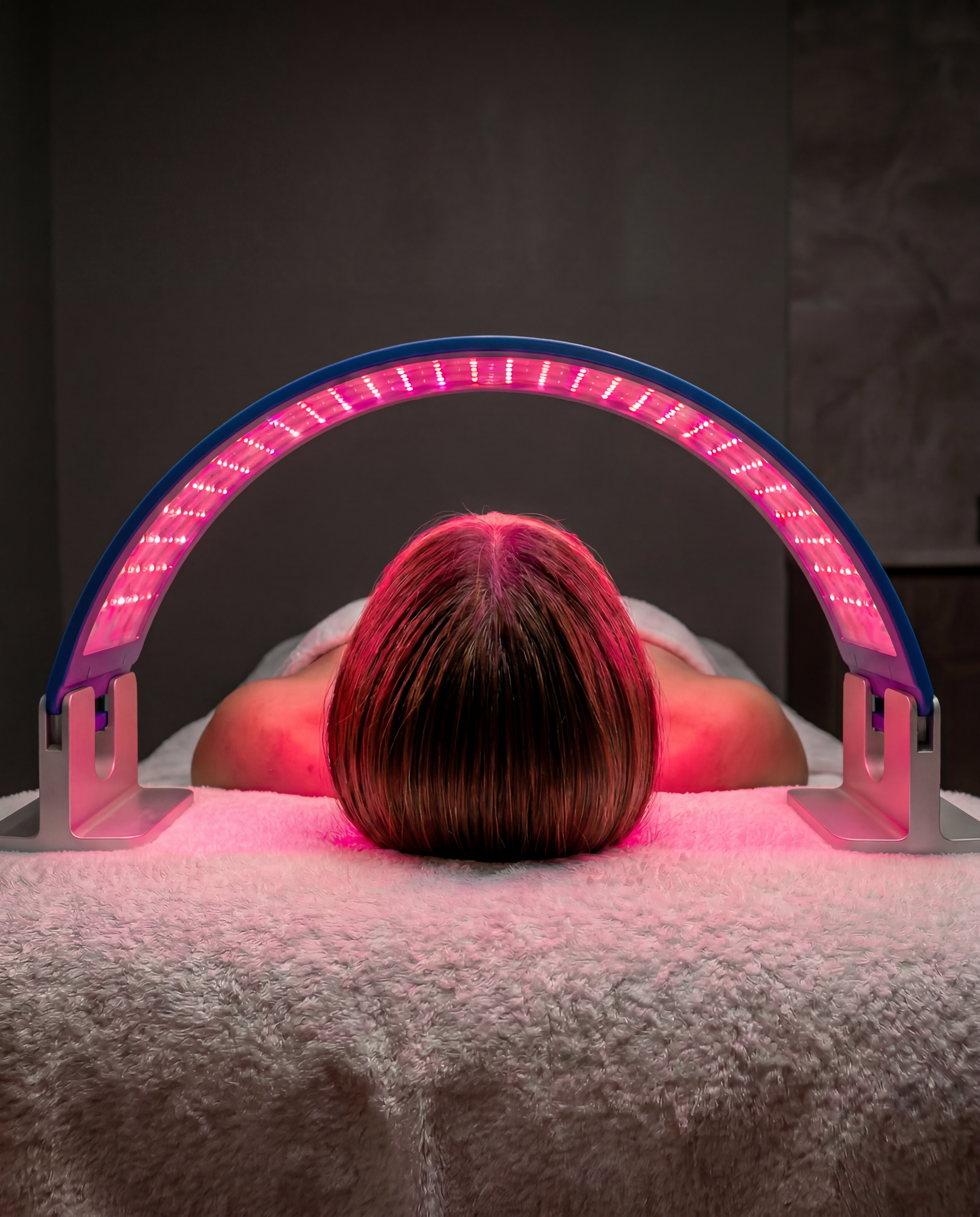 Close up of a woman using a light therapy device on her face