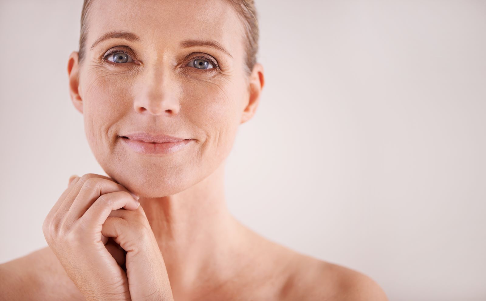 Woman holding skincare devices on a clean white background