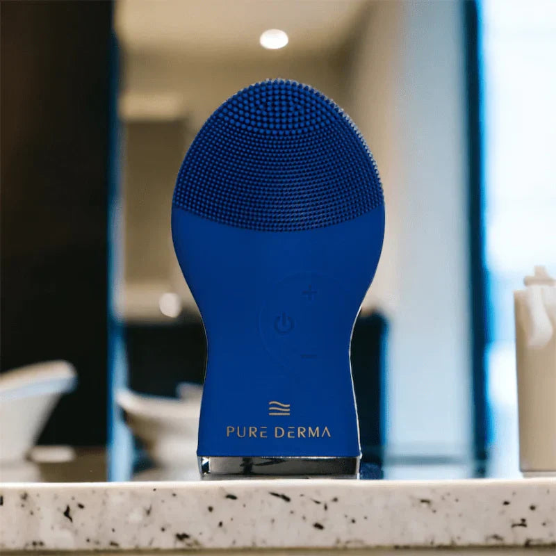 Pure Derma ultrasonic silicone facial cleansing brush on a bathroom countertop