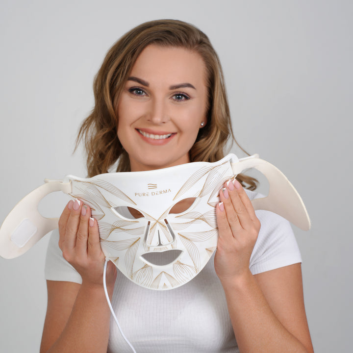 female model holding Pure Derma London LED light therapy face mask